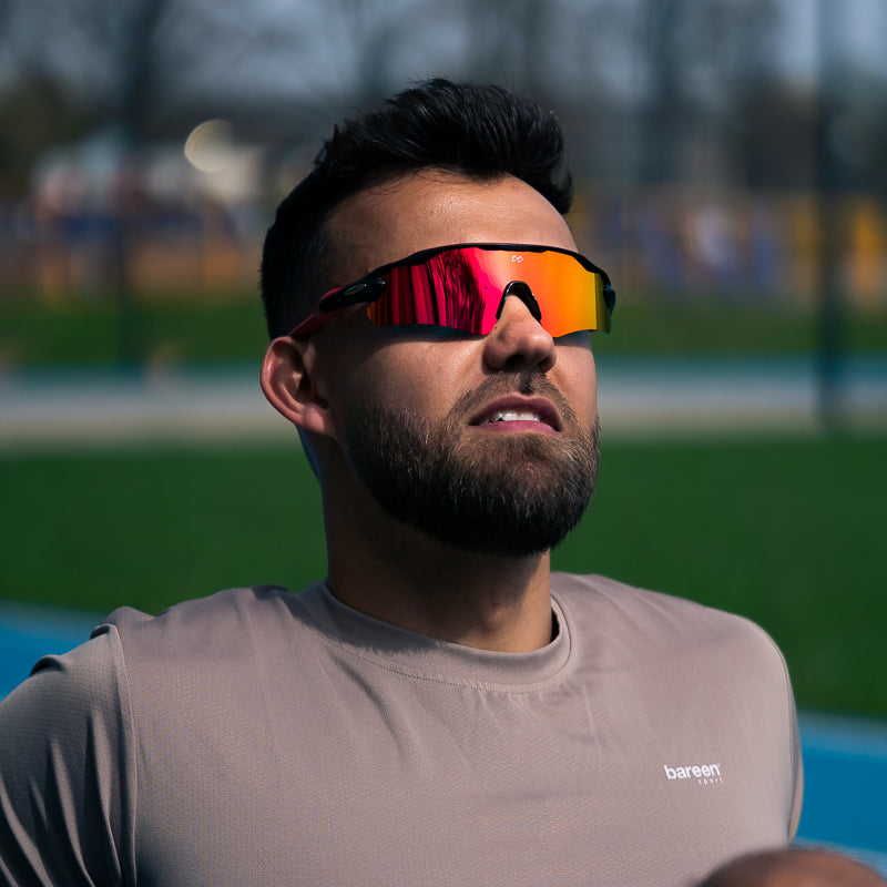 Mand med Triton sportsbriller i Crimson Red på atletikbanen